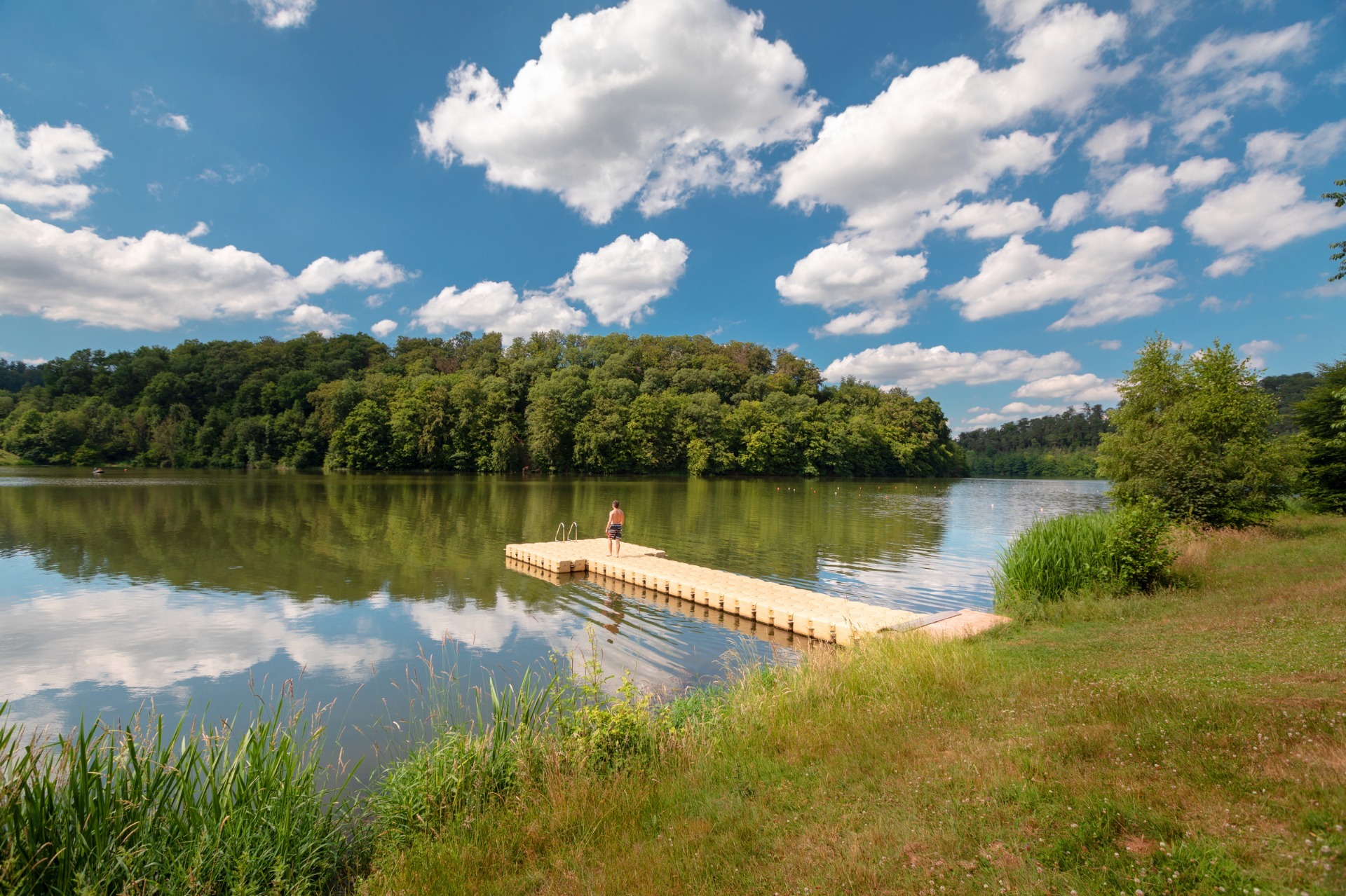 Person auf einem Steg am See