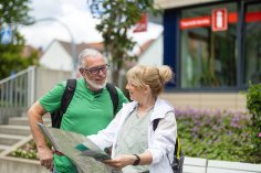 Paar mit Wanderkarte vor der Touristik-Information